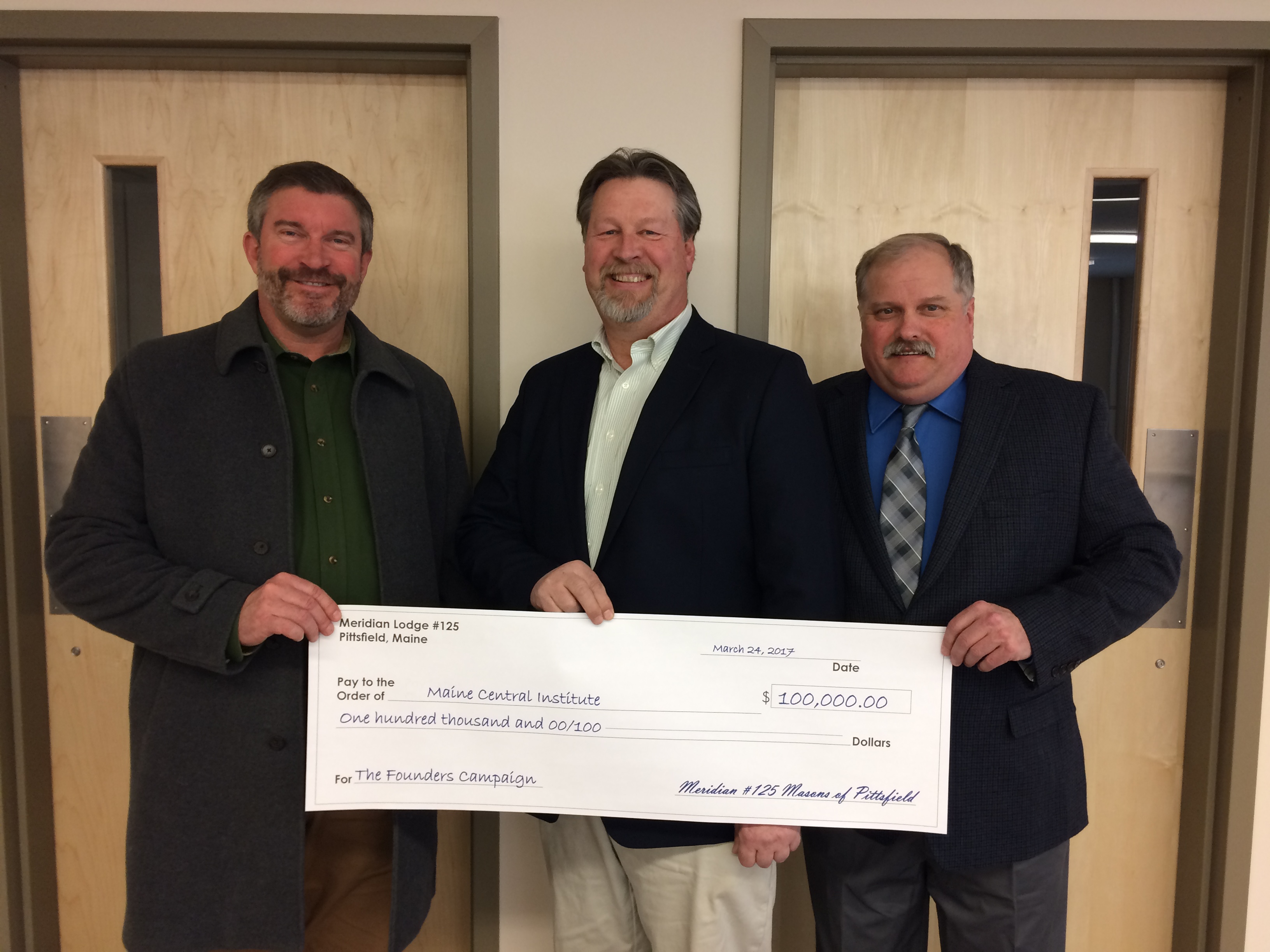 Christopher Hopkins, Stacey Fitts and David Wright with Meridian Lodge’s gift to Maine Central Institute in 2017